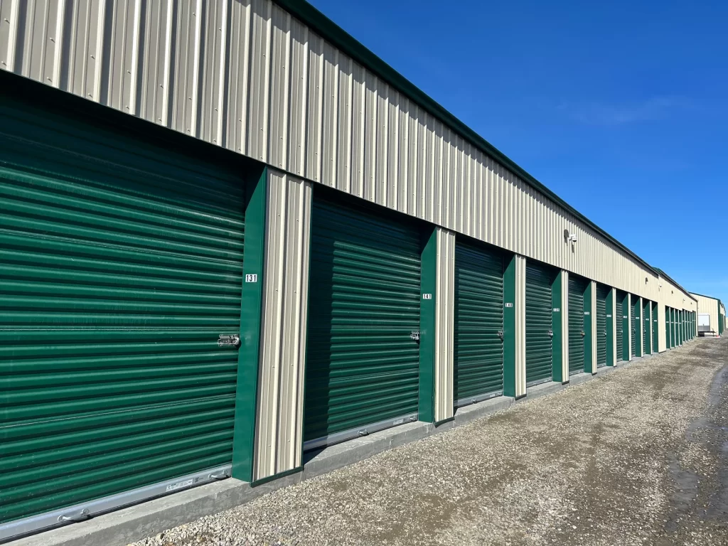 Row of storage units. Green storage doors next to each other, with an HD security cameras for surveillance