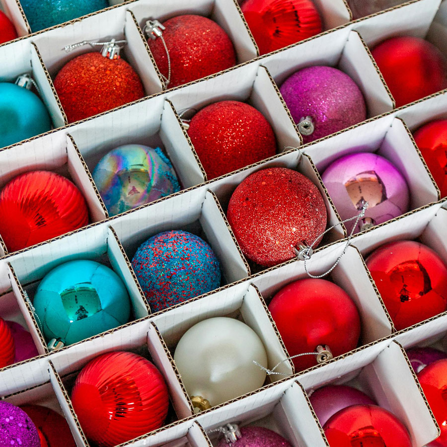 A box of colorful Christmas ornaments ready for seasonal organization during the holidays with Uncle Bob’s.